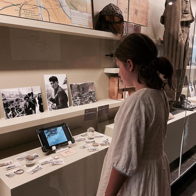 Une petite fille regardant un documentaire mis à disposition dans le musée de l'Horlogerie