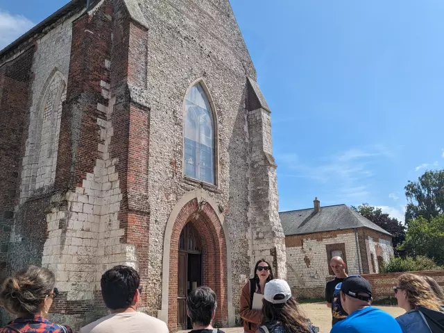 Groupe assis écoutant un guide devant une église