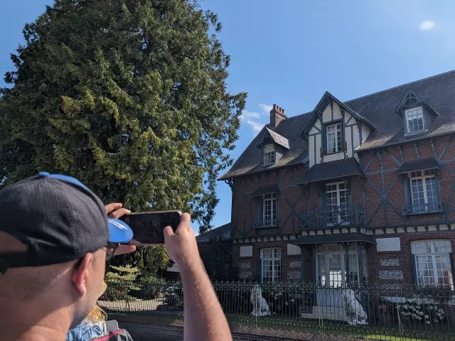 Homme prenant une photographie d'une maison