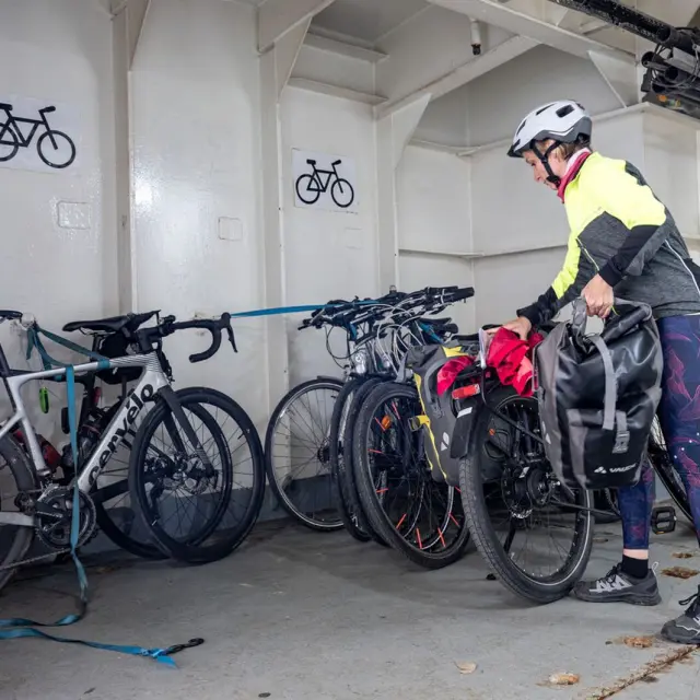 Une femme accroche son vélo dans la soute du ferry DFDS Dieppe-Newhaven