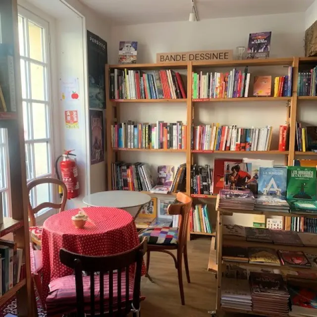 Intérieur chaleureux de la librairie-salon de thé La Grande Ourse à Dieppe, avec des étagères de livres, quelques tables pour une pause lecture et une ambiance conviviale.