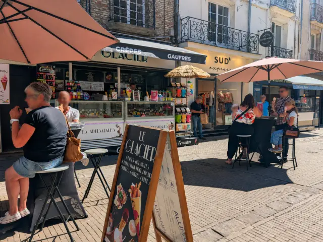Visiteurs dégustant des glaces en terrasse devant un glacier de la Grande Rue, dans le centre-ville de Dieppe.