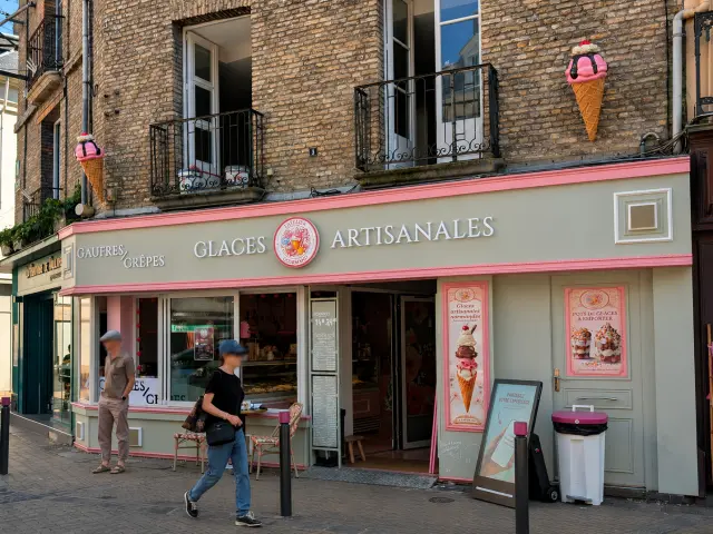 Glacier artisanal dans une rue commerçante du centre-ville de Dieppe, avec des visiteurs passant devant la boutique.