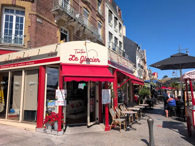 Façade de Tonton Le Glacier et sa terrasse sur le quai de Dieppe, avec des visiteurs installés sous les parasols.