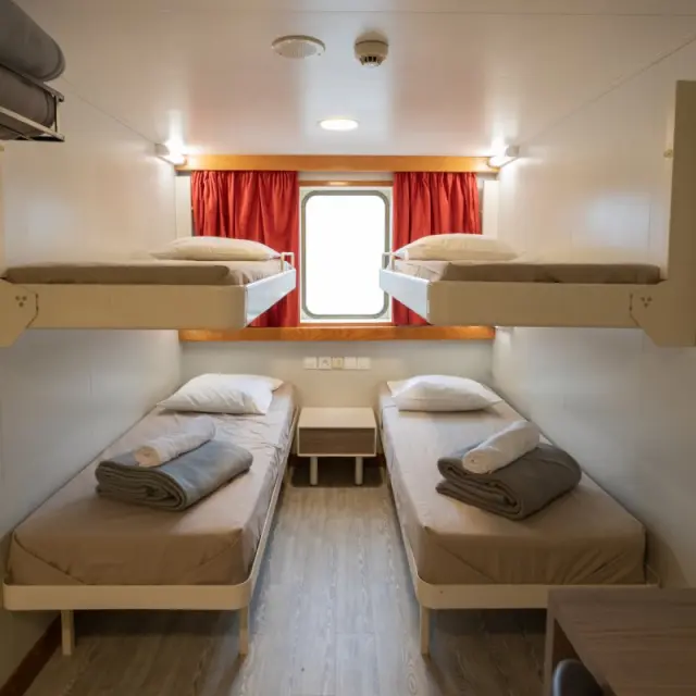 Cabine du ferry Transmanche équipée de quatre couchages individuels, prête à accueillir les passagers pendant la traversée.