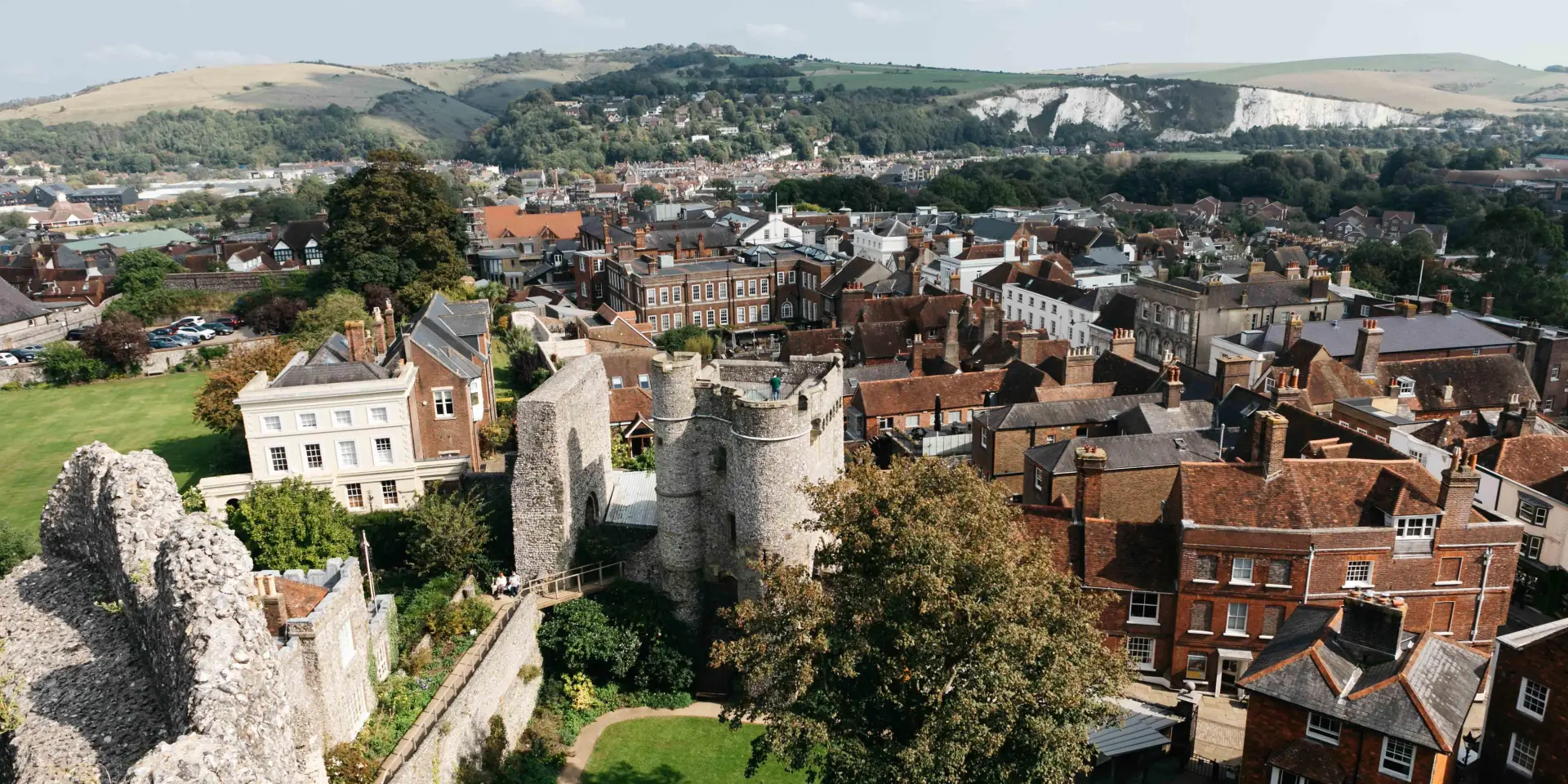 Vue panoramique sur Lewes depuis les ruines du château, avec les toits du centre historique et les collines verdoyantes en arrière-plan.