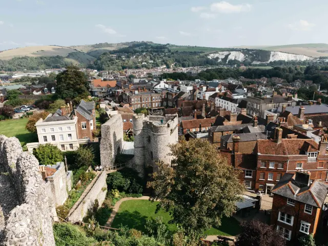 Vue panoramique sur Lewes depuis les ruines du château, avec les toits du centre historique et les collines verdoyantes en arrière-plan.